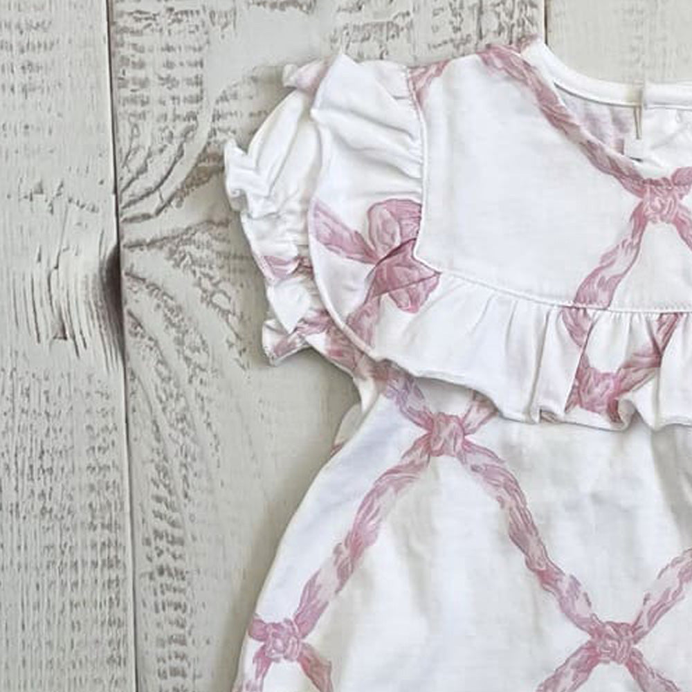Blusa blanca con estampado rosa y olanes; manga abullonada y abertura en el escote