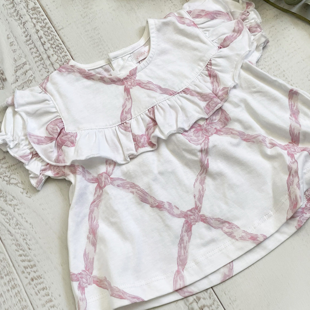 Blusa de algodón blanca con estampado rosa tipo lazos y falda con volante