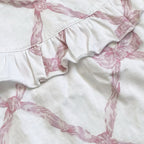 Blusa blanca con estampado rosa; volante fruncido en la parte delantera