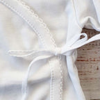 Chambrita blanca con lazo frontal y terminados con puntada decorativa