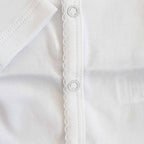 Body blanco para bebé: broches circulares en la costura frontal