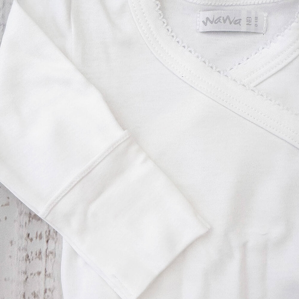 Detalle del body blanco: costuras cruzadas y ribete con acabado picot