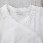 Cuello en pico del body blanco con broche lateral y vivos con picot