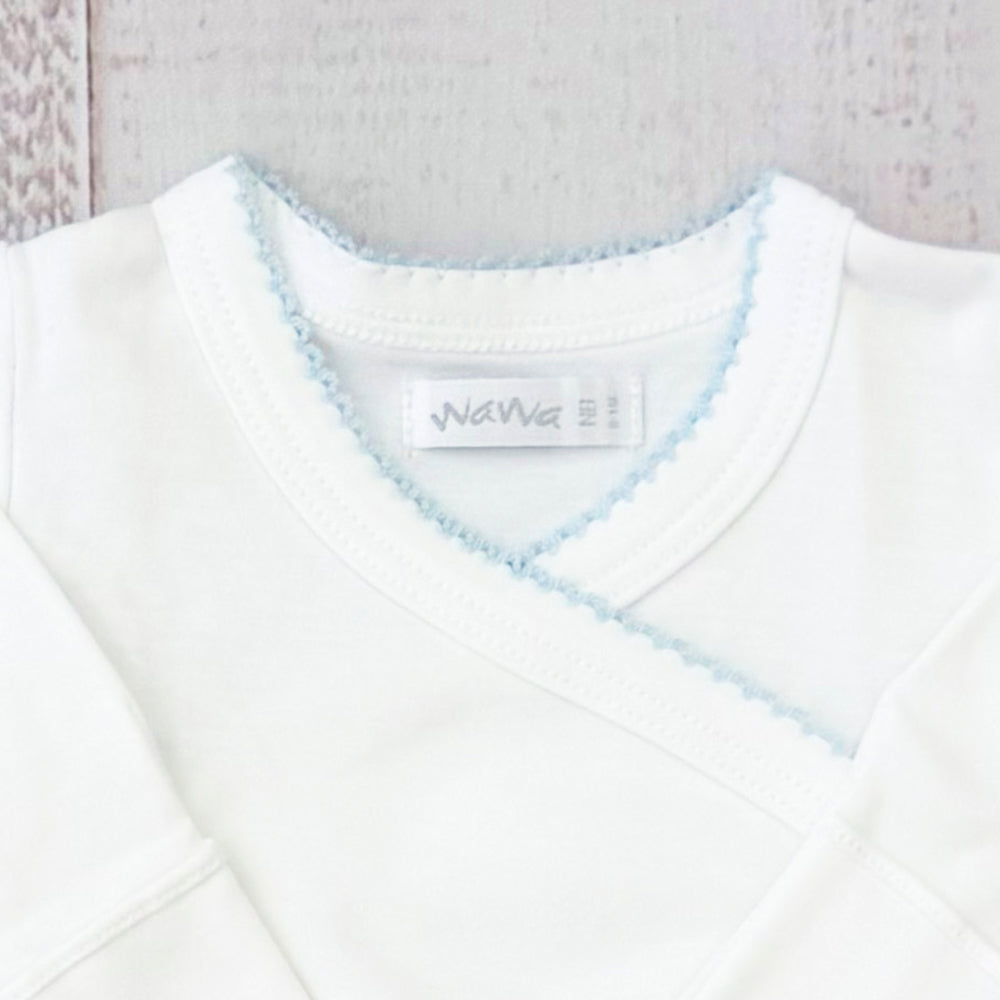 Body infantil blanco con escote en V y ribete celeste picot; etiqueta en el cuello