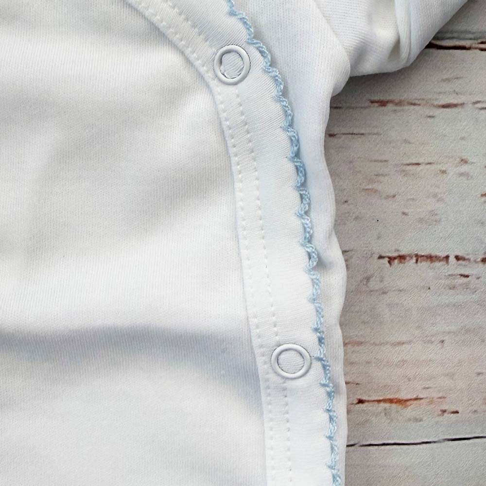 Body celeste básico con ribete picot azul y botones a presión en el costado