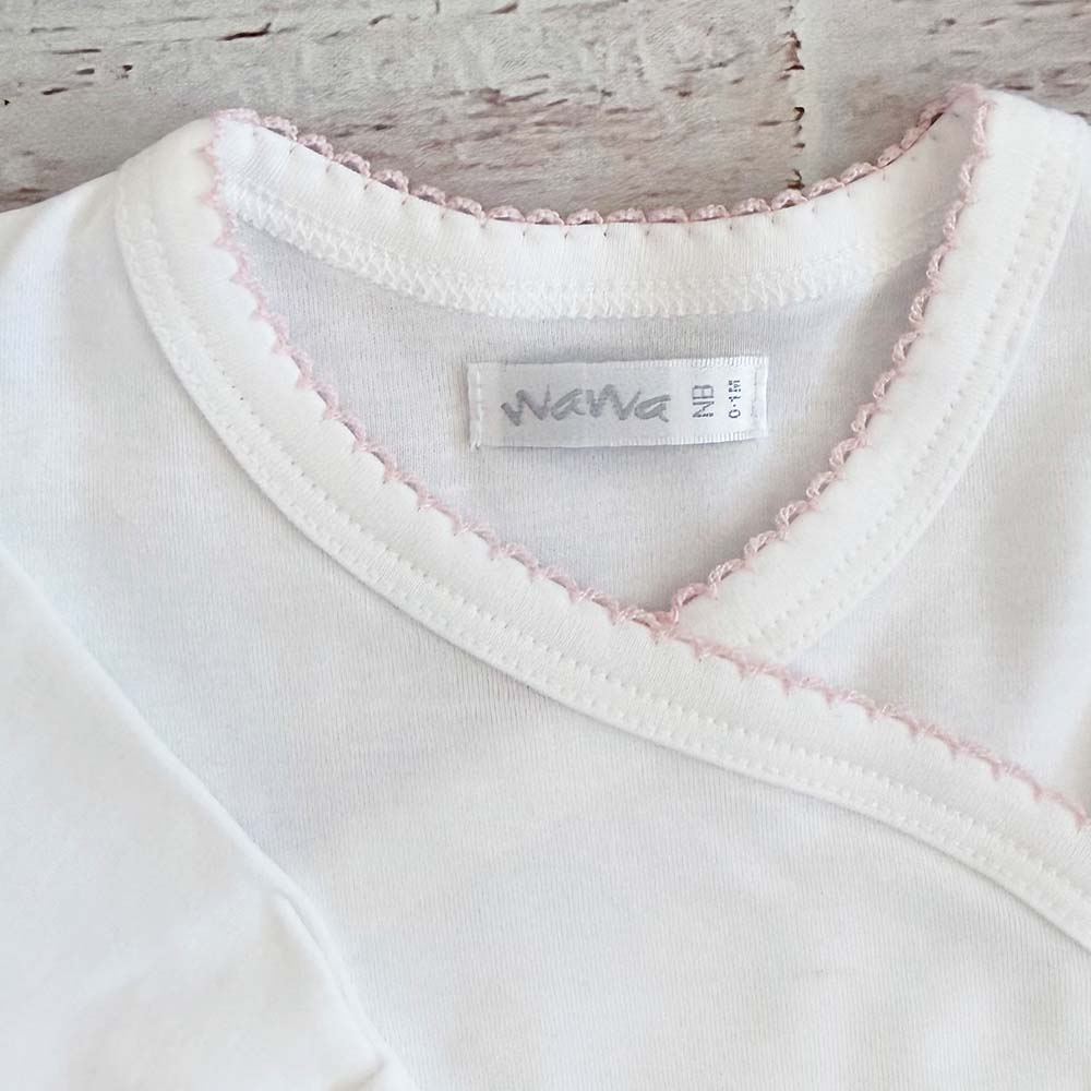 Cuello de body blanco con ribete picot rosado y etiqueta interior