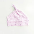 Gorro infantil rosado con nudo en la parte superior y estampado repetido de coronas.