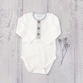 Body infantil blanco de manga larga con tapeta a rayas grises y botones de madera