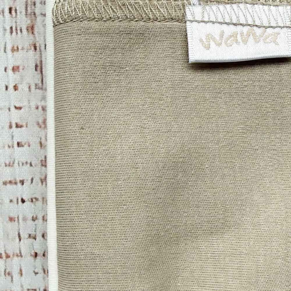 Tejido beige con costuras y ribete en la parte superior, etiqueta blanca parcial