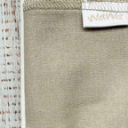 Tejido beige con costuras y ribete en la parte superior, etiqueta blanca parcial