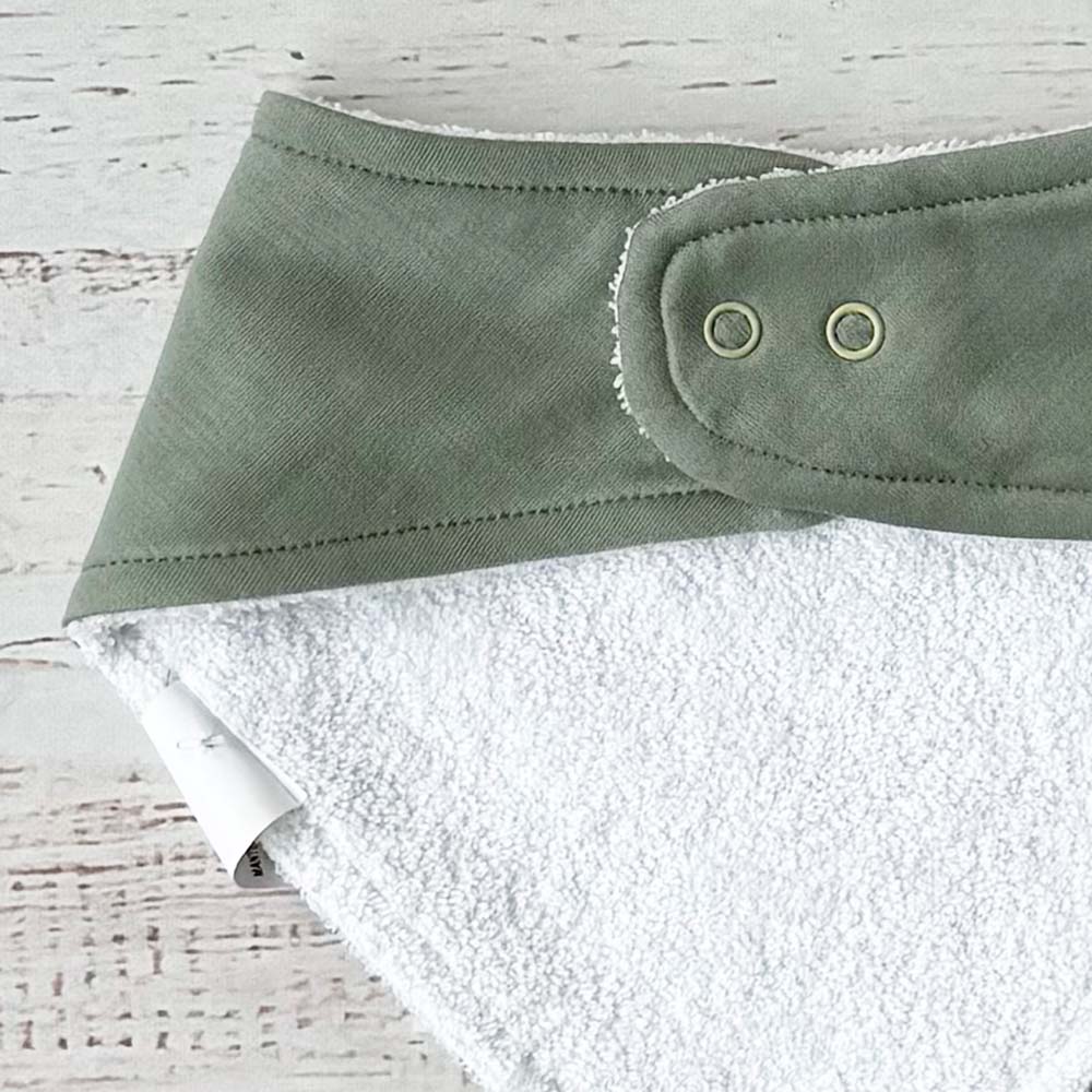 Bandana verde triangular con broches circulares en el cuello y reverso blanco