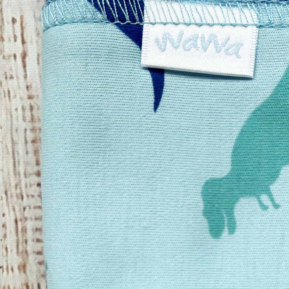 Tuto azul claro con estampado de dinosaurio y etiqueta WaWa en la parte superior