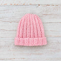 Gorro de lana rosado tejido tipo beanie, dobladillo acanalado y punto grueso.