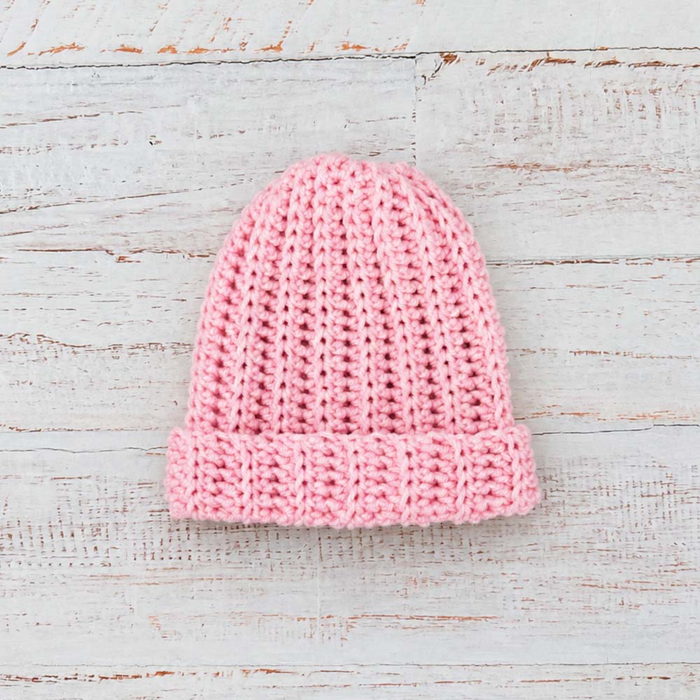 Gorro de lana rosado tejido tipo beanie, dobladillo acanalado y punto grueso.