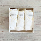 Pack de 3 bodies blancos con borde picot amarillo dentro de caja de regalo