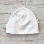 Gorro blanco tejido, dobladillo con puntilla rosa y costura central