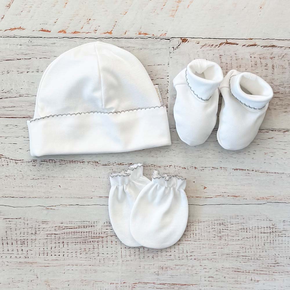Conjunto de bebé: gorro, patucos y manoplas blancas con ribete decorativo