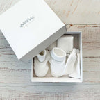 Conjunto de bebé en caja: gorro, patucos y manoplas blancas