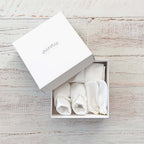 Set de tres prendas blancas en caja: gorro, patucos y manoplas