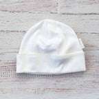 Gorro blanco para recién nacido con borde fruncido y etiqueta interior