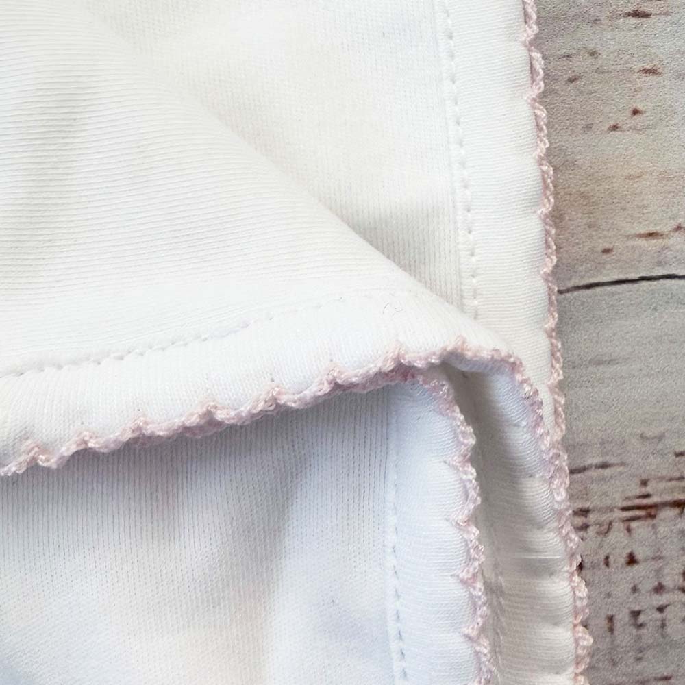 Manta blanca con esquina y ribete picot rosado con pespunte
