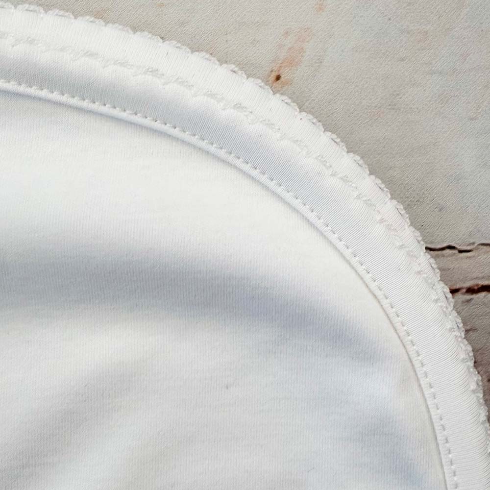 Orilla con costura y acabado con picot sobre tejido blanco