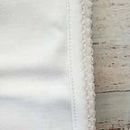 Detalle de costura y ribete con picot en manta blanca