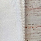 Detalle del borde fruncido de la manta jacquard blanca