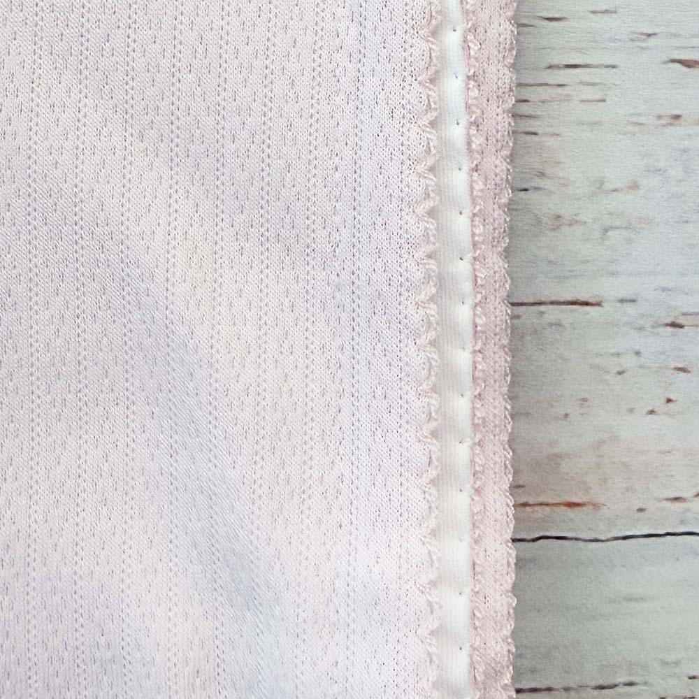 Detalle del tejido jacquard rosado con ribete y pespunte