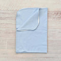 Manta jacquard celeste con borde y diseño trenzado en relieve, doblada