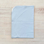 Manta jacquard celeste lisa con borde blanco y caída recta, vista posterior