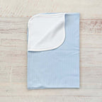 Manta jacquard celeste con vuelta blanca y borde, vista lateral