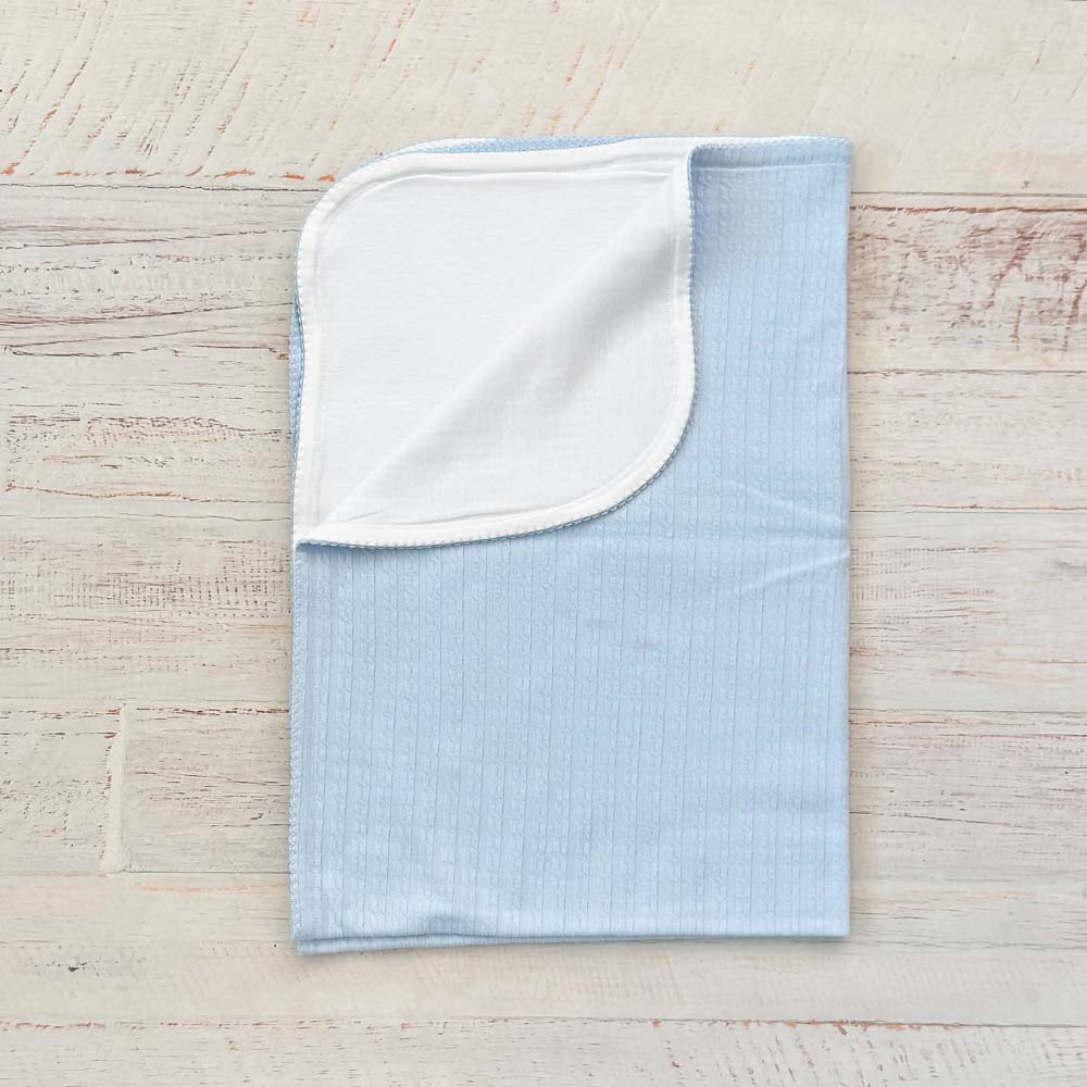 Manta jacquard celeste con vuelta blanca y borde, vista lateral