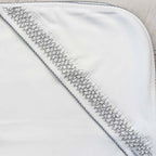 Manta smock gris con franja texturizada y costura a lo largo del borde