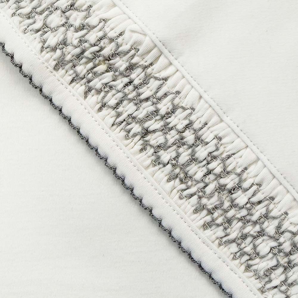 Manta smock gris: franja tejida con textura y costura doble en el borde