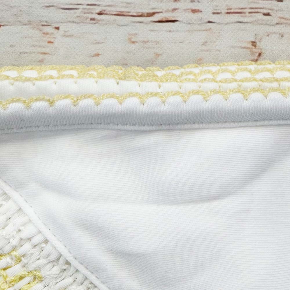 Vista del dobladillo con tejido smock blanco y ribete amarillo ondulado