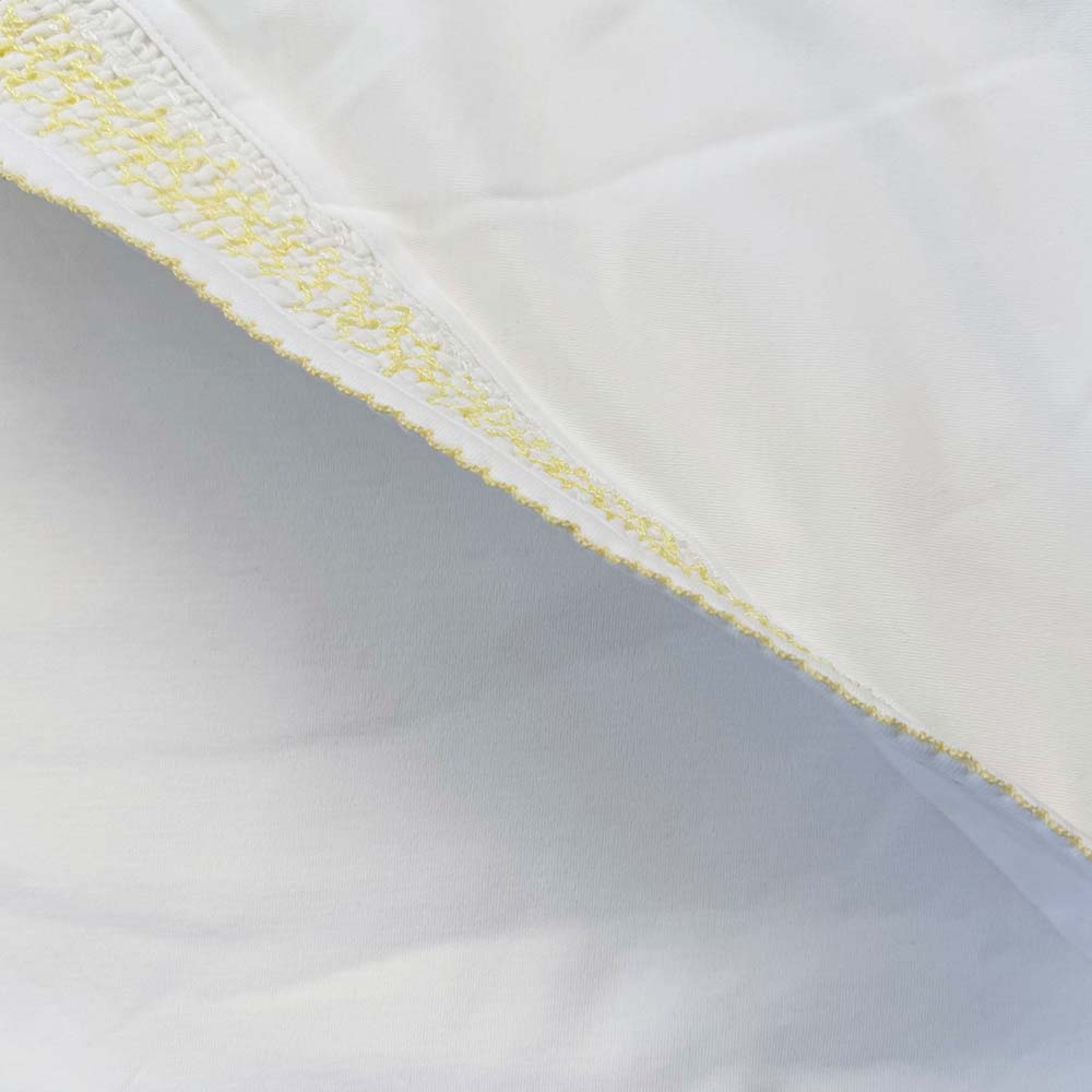 Manta blanca con franja diagonal y ribete amarillo en el borde