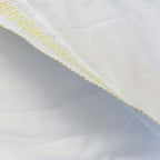 Manta blanca con franja diagonal y ribete amarillo en el borde