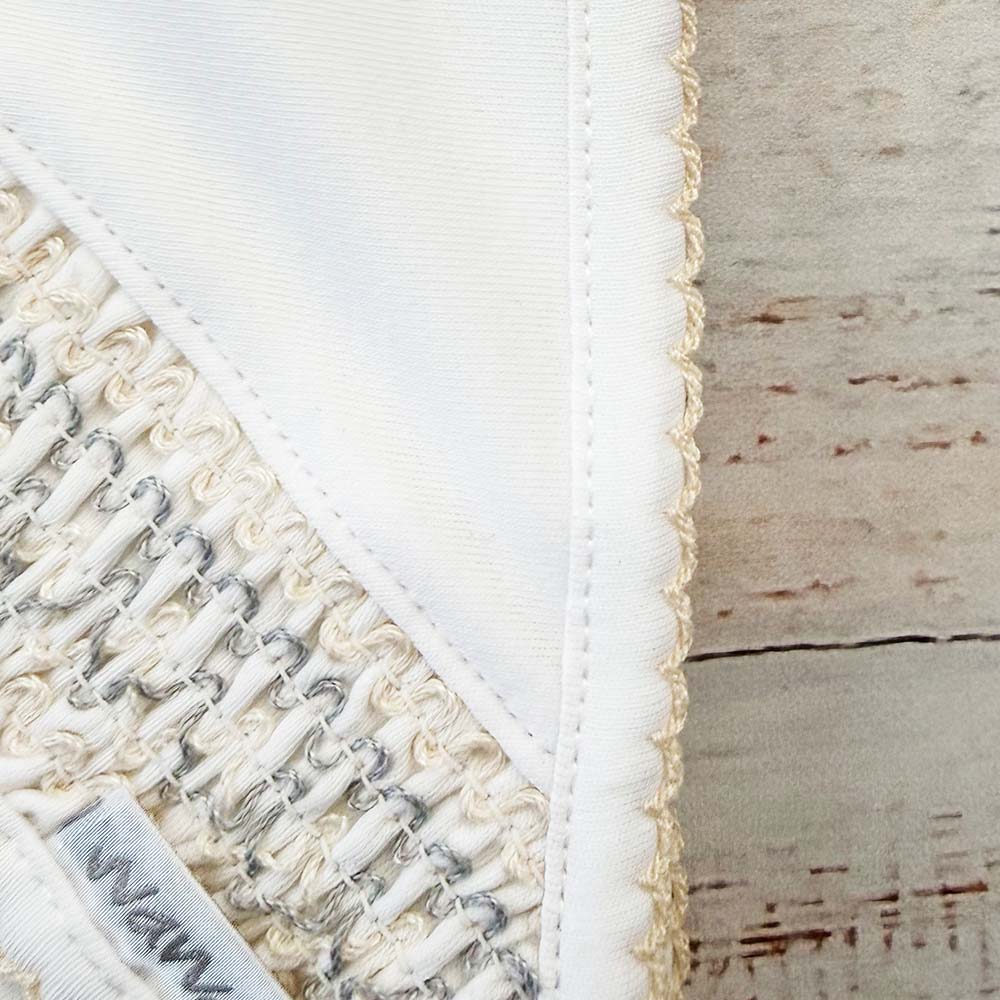 Manta smock beige: detalle de costura del borde y etiqueta interior