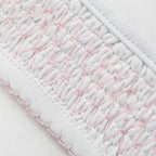 Panel smock con relieve y pequeñas rayas rosadas sobre base blanca
