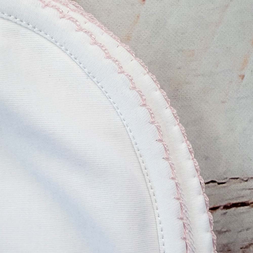 Esquina de manta blanca con costura doble y ribete rosado