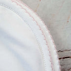 Esquina de manta blanca con costura doble y ribete rosado