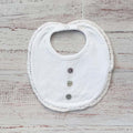 Babero de niño blanco con borde calado y cierre con botones