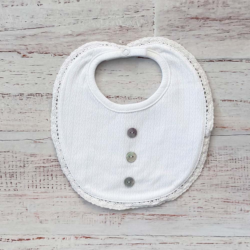 Babero de niño blanco con borde calado y cierre con botones