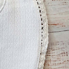 Babero blanco con borde calado y costura lateral