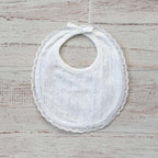 Babero bordado unisex blanco con volante de encaje y broches en la parte superior
