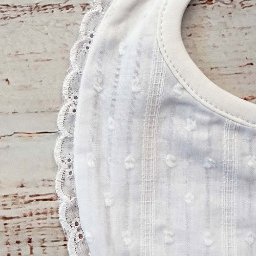 Babero blanco unisex con borde de encaje y abertura redonda para el cuello
