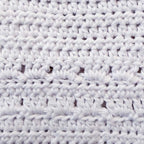 Babero de crochet blanco con patrón de puntos en relieve y líneas horizontales
