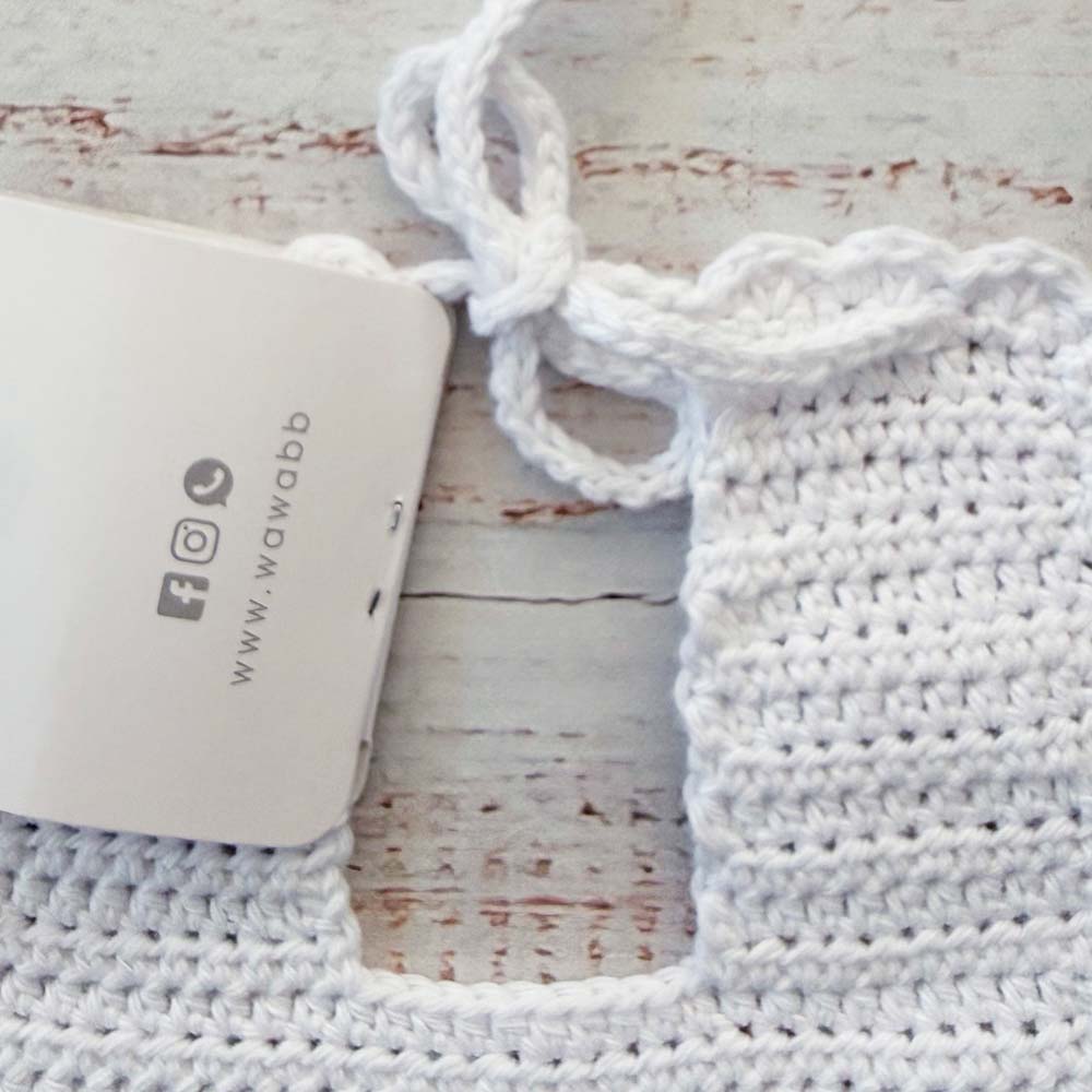 Babero de crochet blanco con correa tejida y etiqueta Wawa baby design