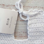 Babero de crochet blanco con correa tejida y etiqueta Wawa baby design